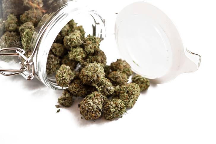 Nuggets of marijuana spill out of a glass jar